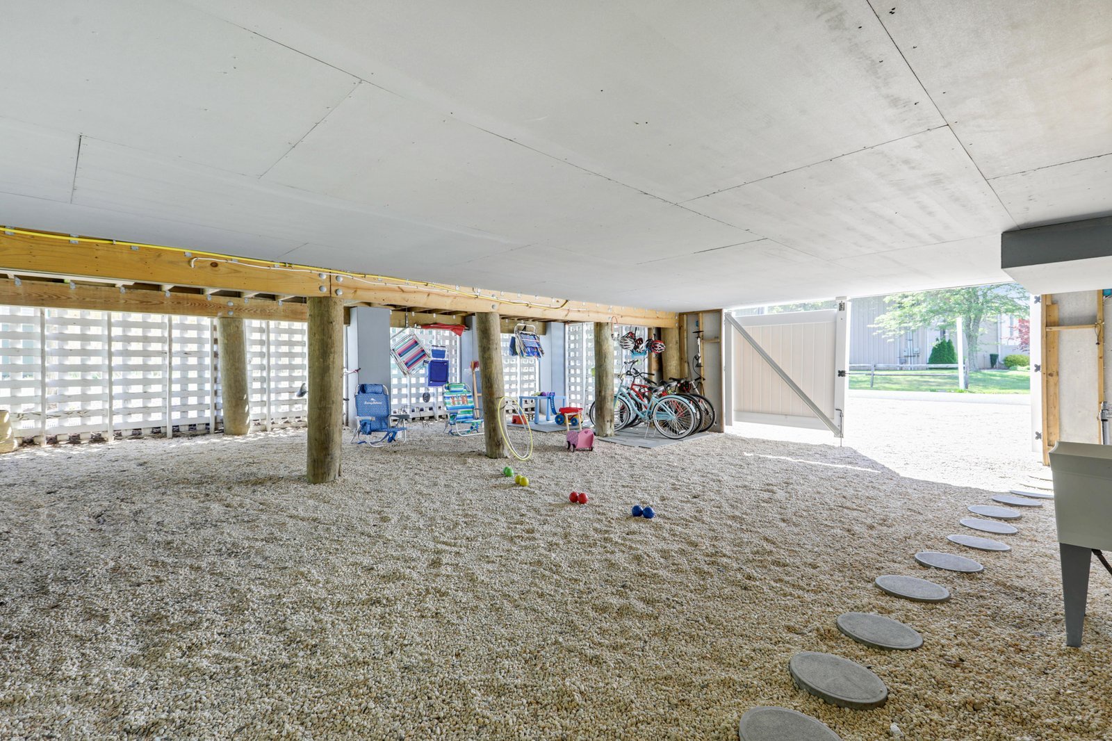 Covered ground-level storage area with space for bikes, beach gear, and outdoor equipment—perfect for stashing your adventure essentials.