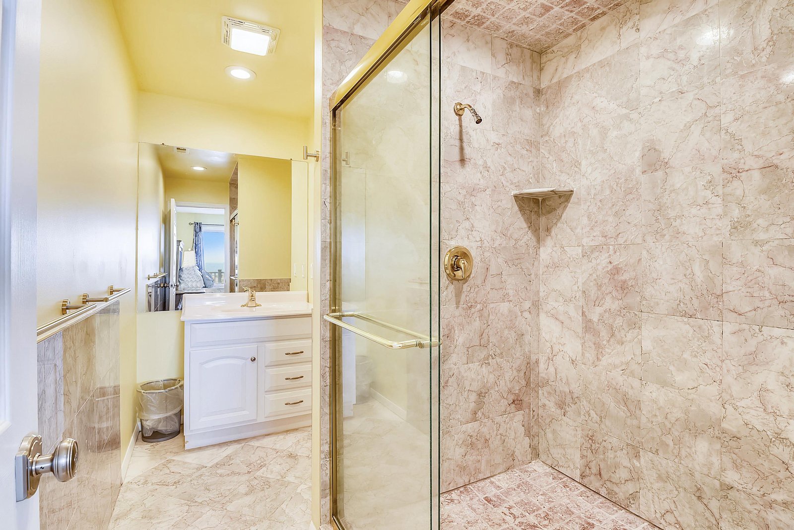Step into your beautifully appointed bathroom, where soft lighting and elegant marble surround you. Enjoy a refreshing rinse in your spacious walk-in shower with gleaming fixtures and glass enclosure.
