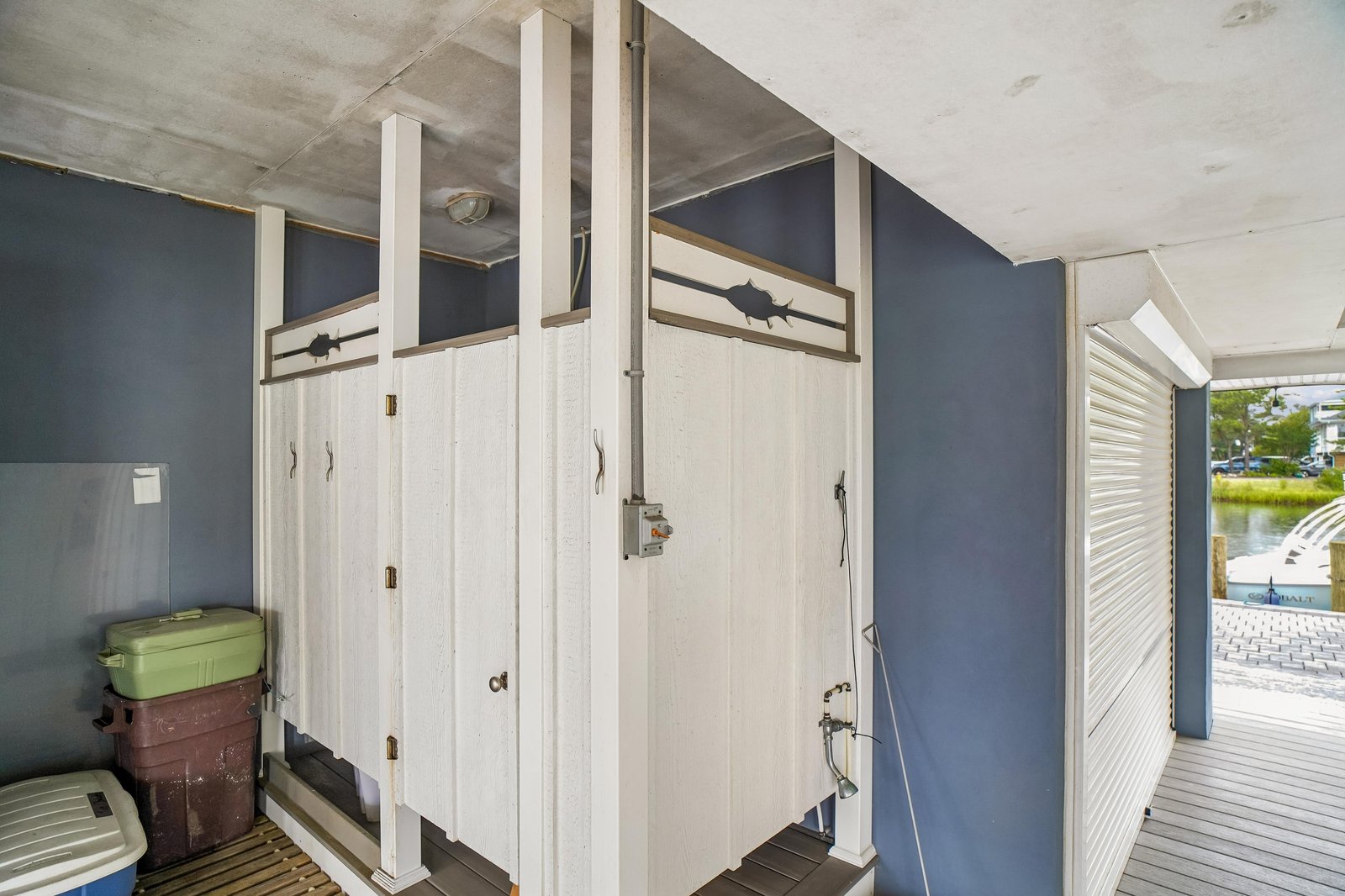 The private outdoor shower stalls offer a refreshing rinse after your beach adventures, with charming coastal details and easy access from the deck overlooking the water.