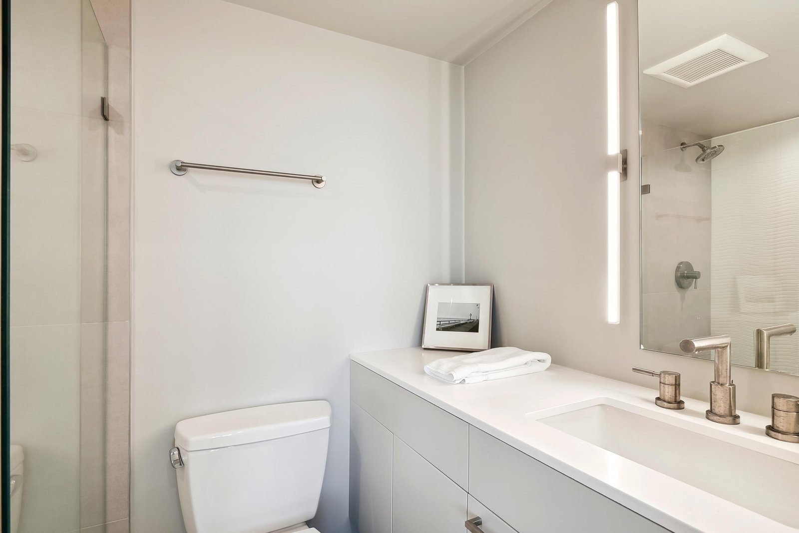 Step into your bright, modern bathroom with a spacious walk-in shower, soft ambient lighting, and fresh towels at the ready—designed for your comfort and relaxation.