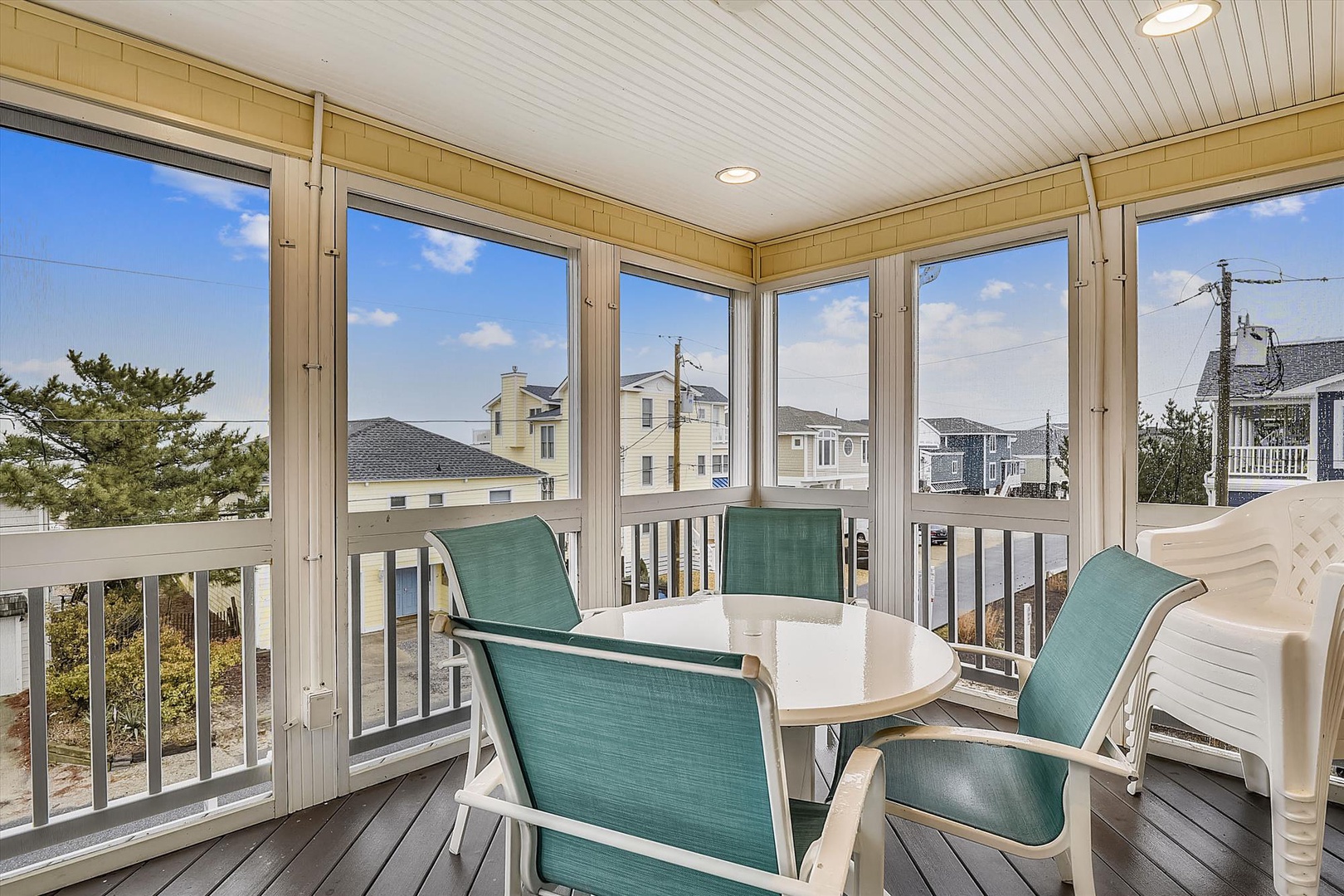 Step onto your private screened porch and enjoy morning coffee or evening cocktails around the cozy table, with fresh coastal breezes and peaceful neighborhood views all around.