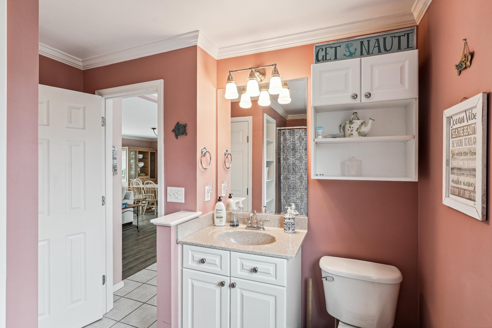 Step into your serene coastal retreat, where warm coral tones and beachy accents create a soothing atmosphere. Fresh towels await, and thoughtful nautical touches invite you to unwind.