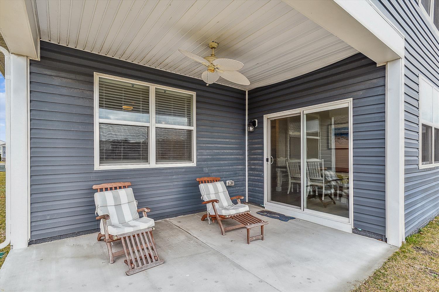Unwind on your private covered patio with comfortable lounge chairs and ceiling fan, perfect for morning coffee or evening relaxation.