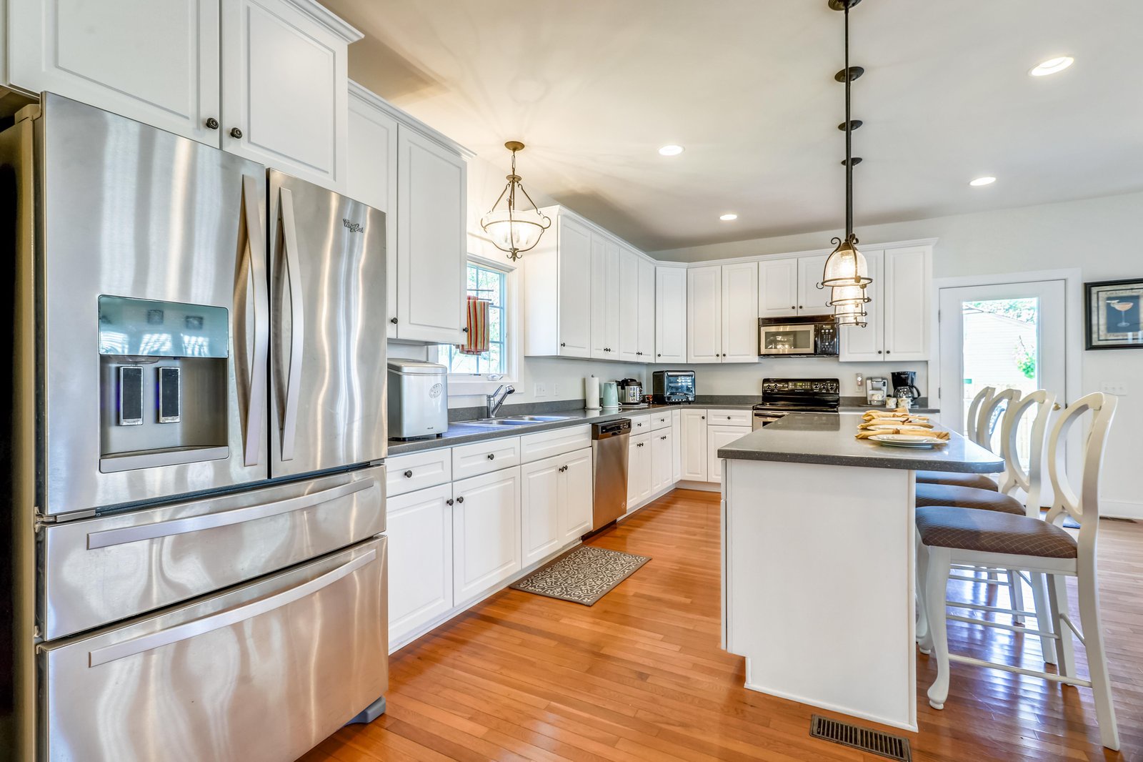 Gather around the spacious island in your bright, fully-equipped kitchen, where gleaming countertops and stainless steel appliances make preparing family meals a joy.