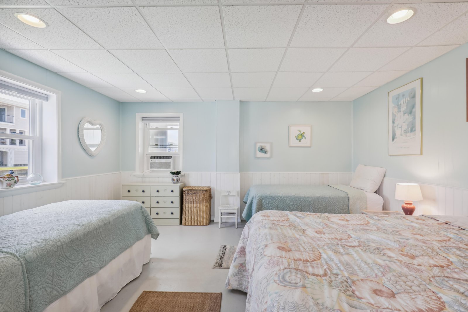Unwind in your tranquil coastal retreat with three comfortable beds and soft sea-foam walls. Natural light floods through the windows, while gentle coastal artwork creates the perfect atmosphere for your seaside escape.