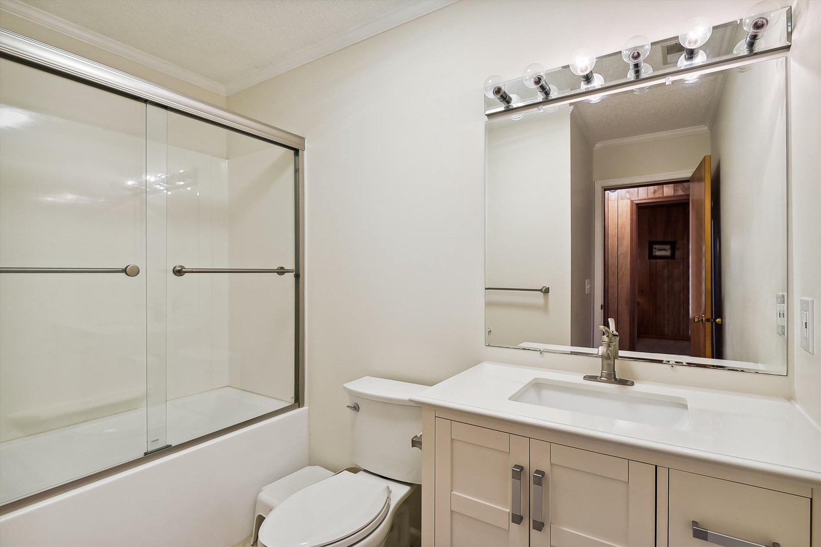 Your private bathroom features a spacious vanity with ample counter space, a clean bathtub-shower combination, and bright lighting to start your day refreshed.