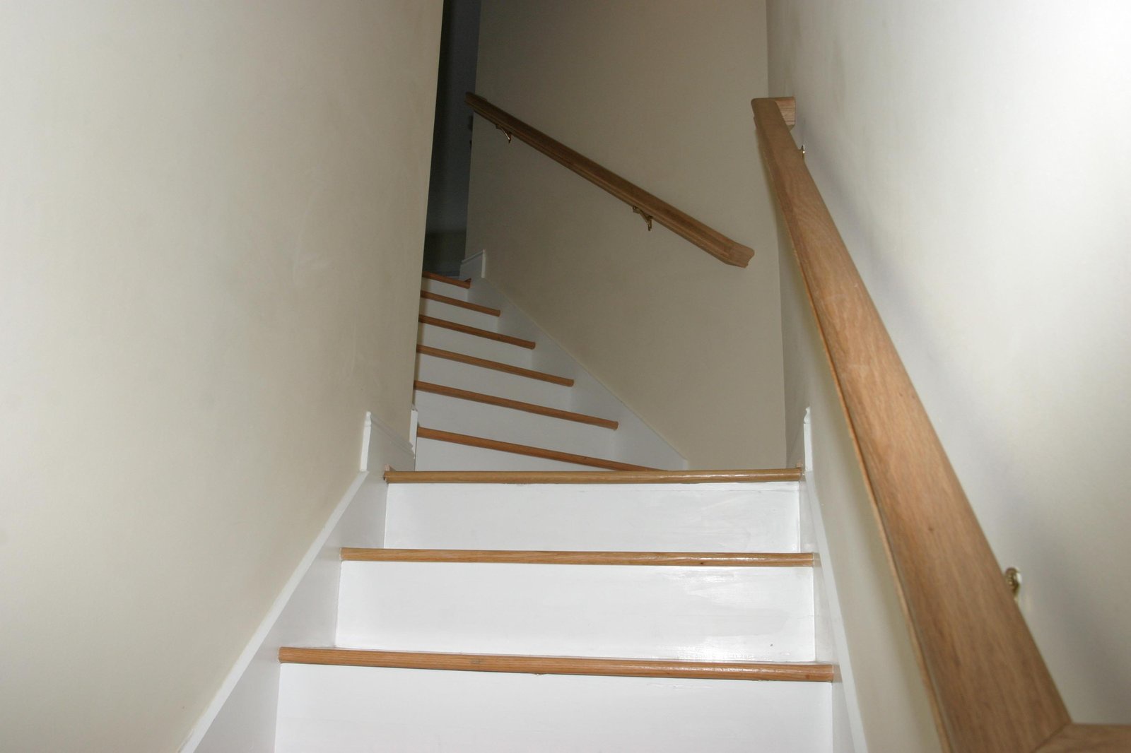 A bright, modern staircase with warm wooden steps and sleek railings connects your living spaces, blending style with functionality.