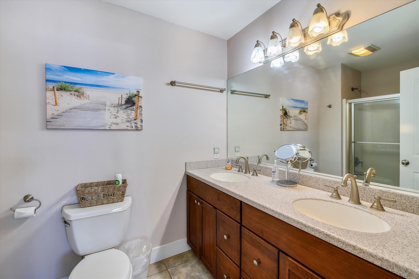 Step into your private sanctuary with dual vanities, warm wood cabinetry, and soft lighting that sets a relaxing tone. Fresh towels await after a refreshing shower.