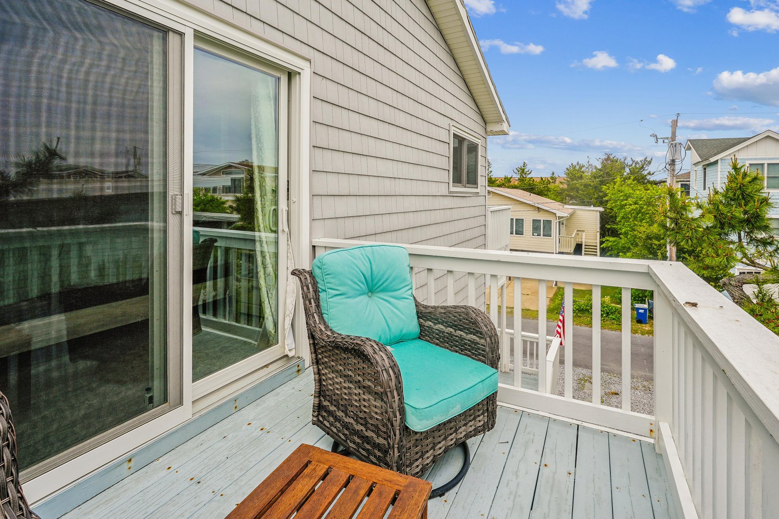 Step onto your private balcony and settle into the cozy chair with turquoise cushions, soaking in neighborhood views and fresh air under open skies.