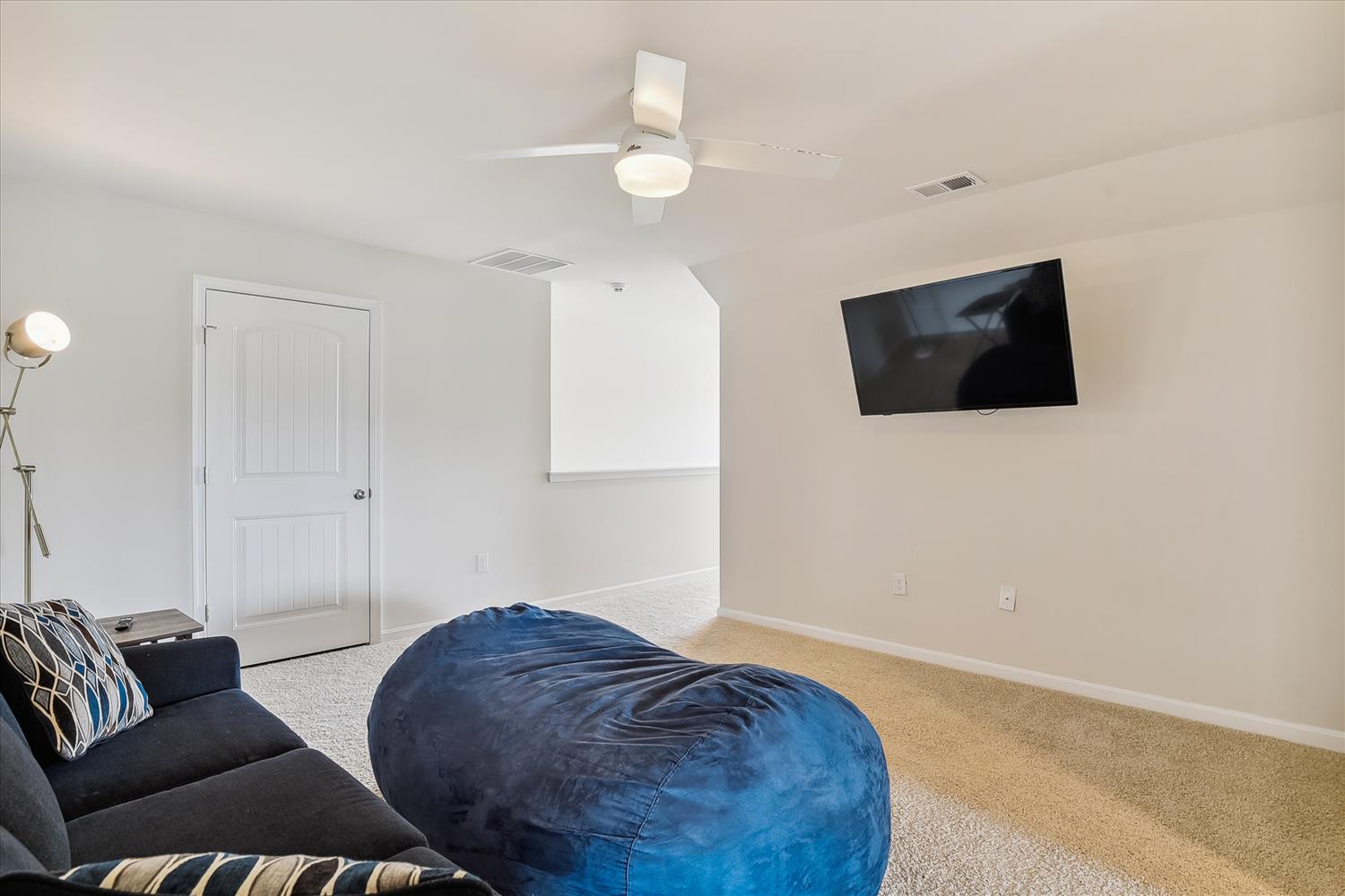 Kick back in your personal lounge with a giant bean bag, wall-mounted TV for movie nights, and a ceiling fan to keep you comfortable—your perfect spot to unwind.