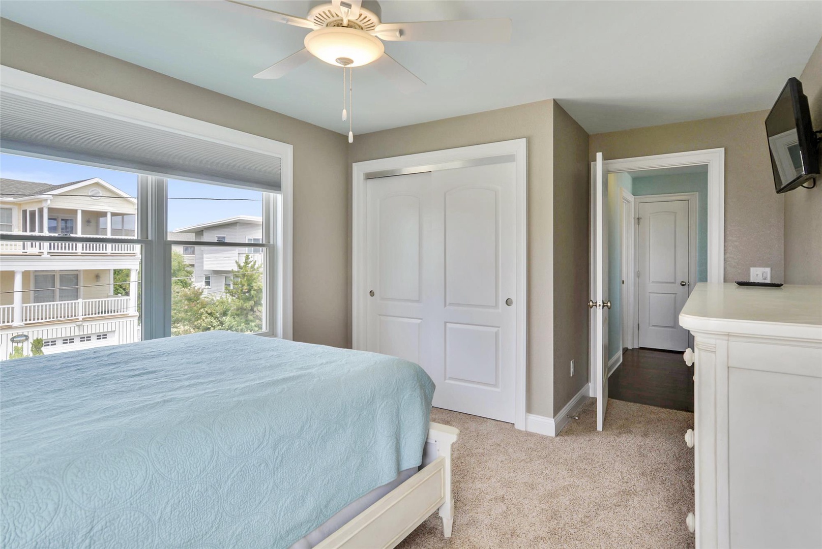 Rest easy in your bright, serene bedroom with soft linens, ample closet space, ceiling fan, and peaceful neighborhood views just beyond your window.