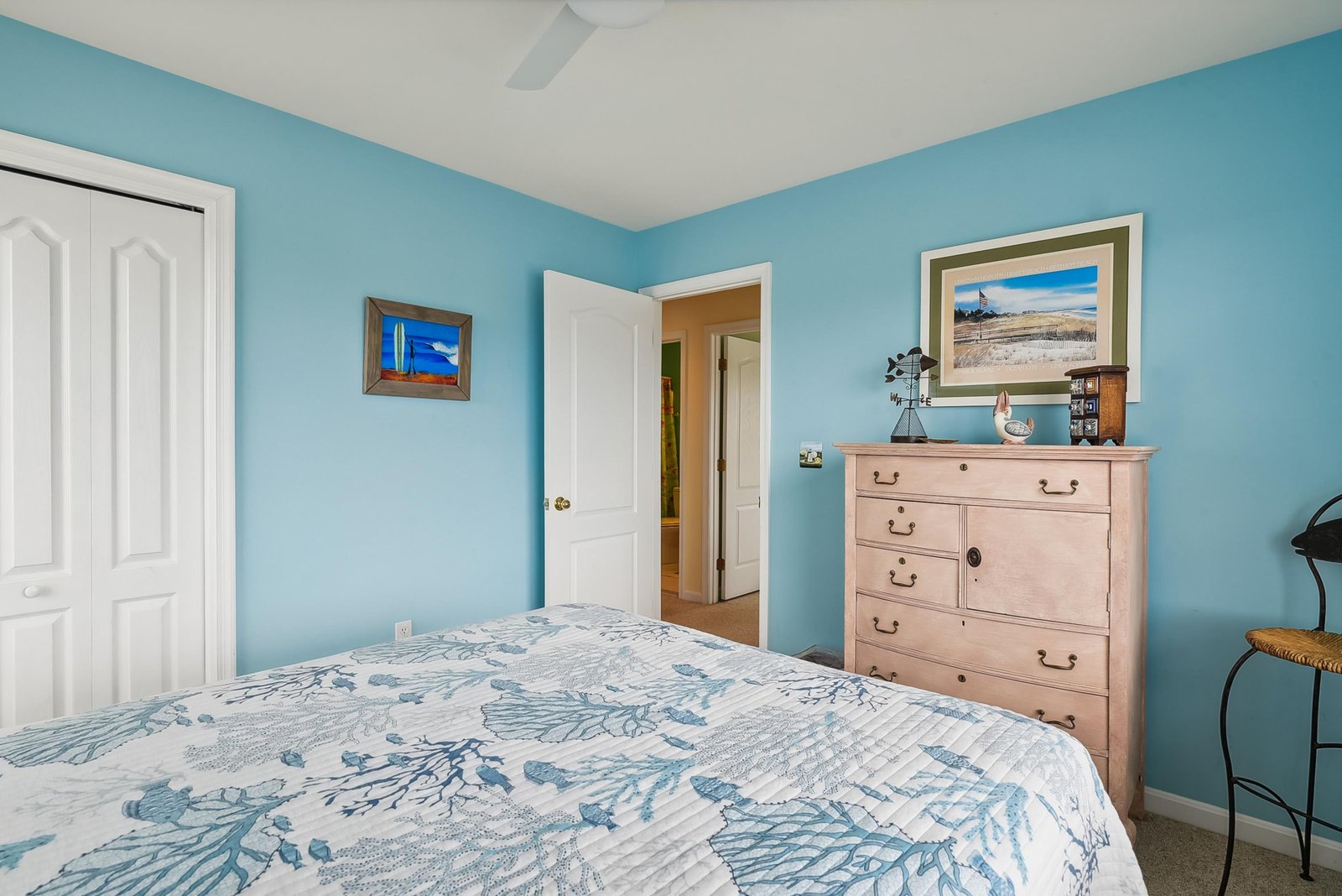 Unwind in your tranquil bedroom, where soft coastal blue walls and a plush bed invite you to relax after a day of adventure. The vintage dresser and gentle ceiling fan add character and comfort to your private retreat.