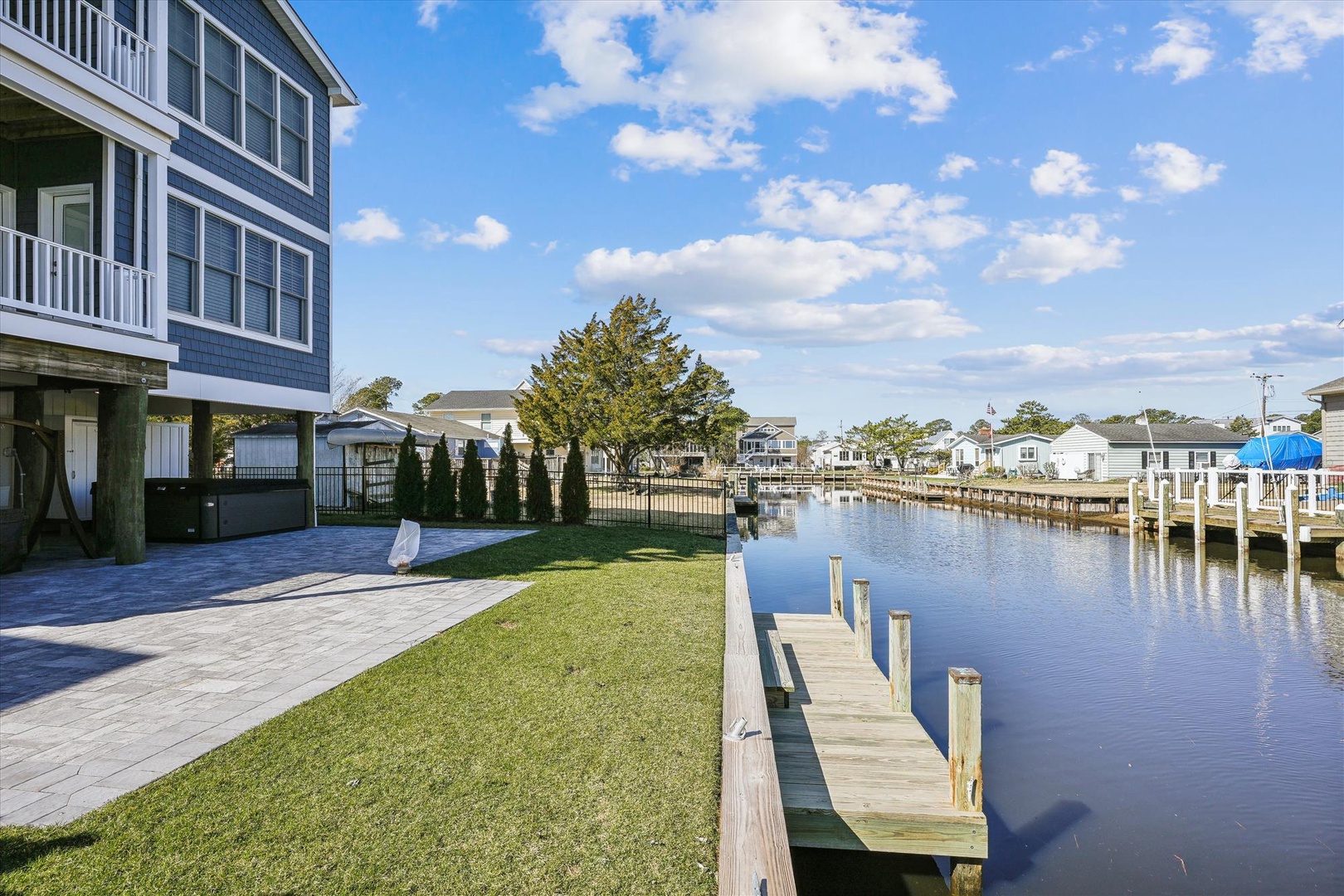 The property features a private waterfront backyard with a personal boat dock and expansive lawn, nestled in a quiet canal neighborhood with direct water access.