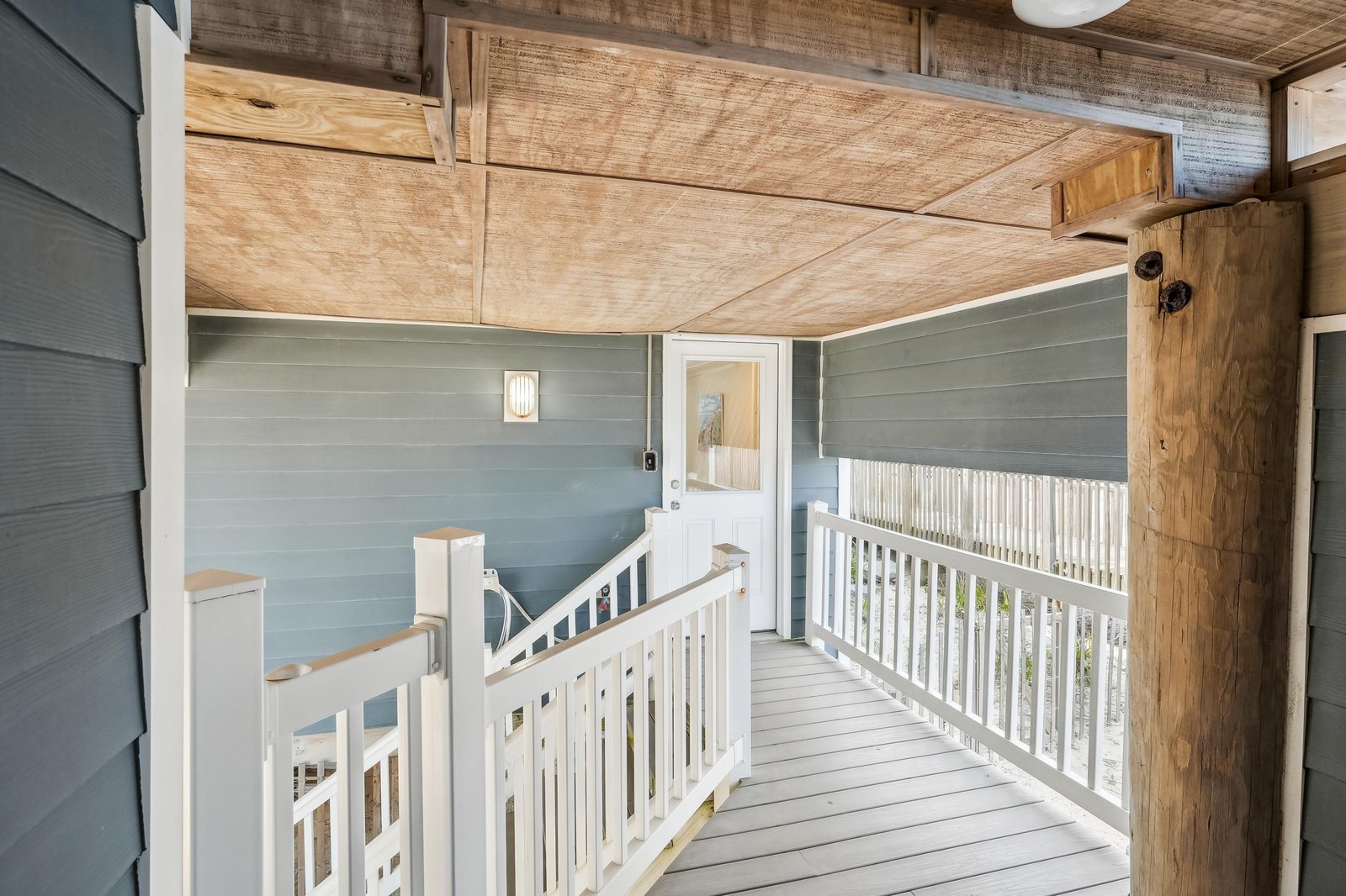 Step out onto your private covered porch where coastal charm meets rustic elegance, featuring warm wood ceilings and refreshing natural light.
