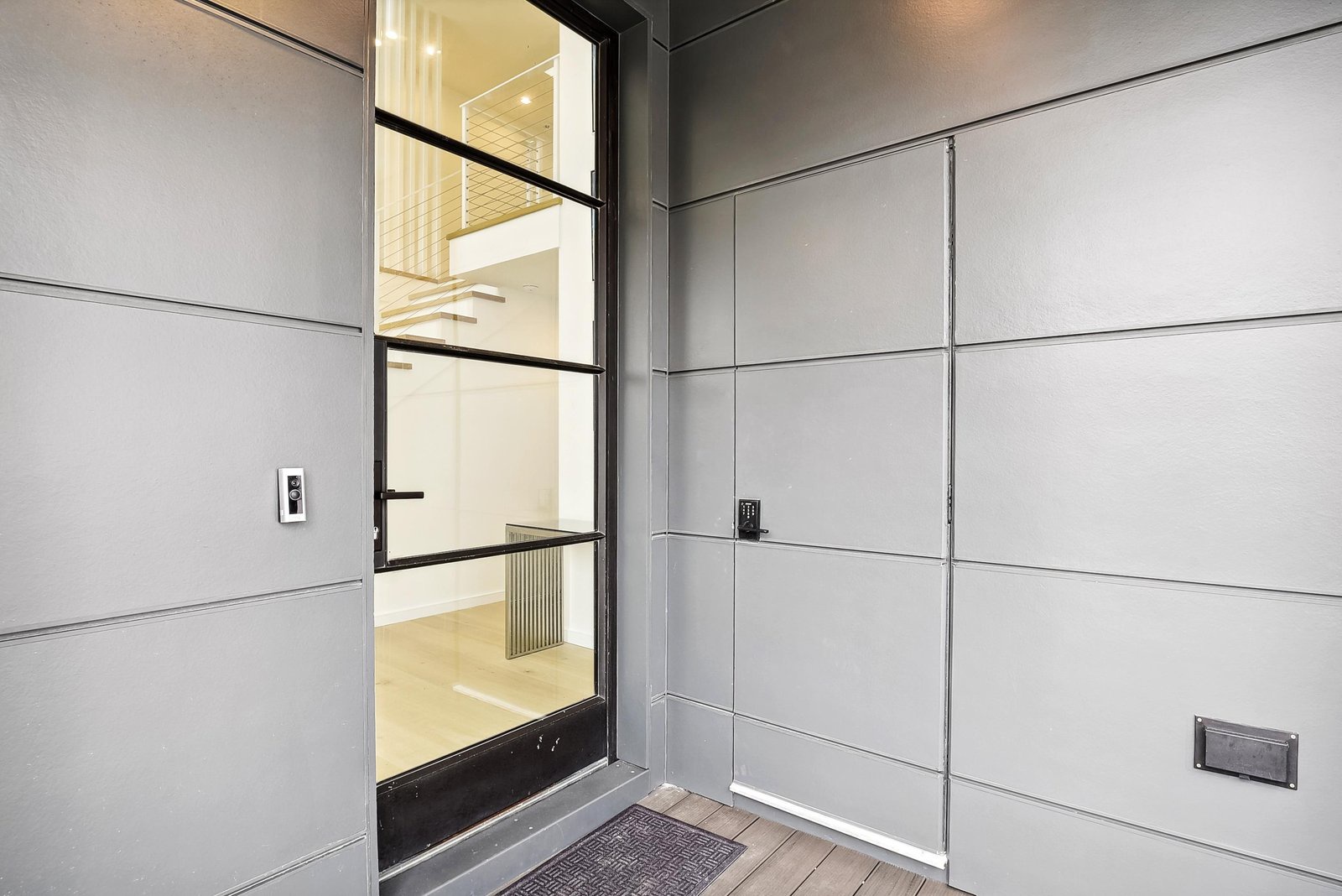 A modern front entrance greets you with sleek industrial design and a welcoming glimpse inside.