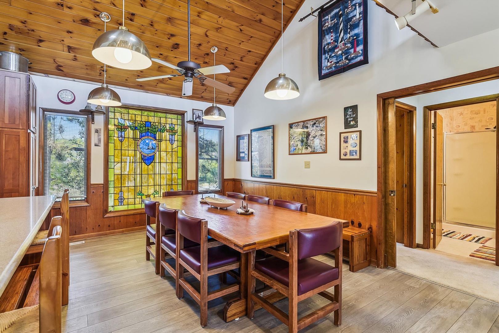 Gather around a warm wood table beneath stunning stained glass for memorable meals in a dining space that blends rustic charm with artful details and inviting light.