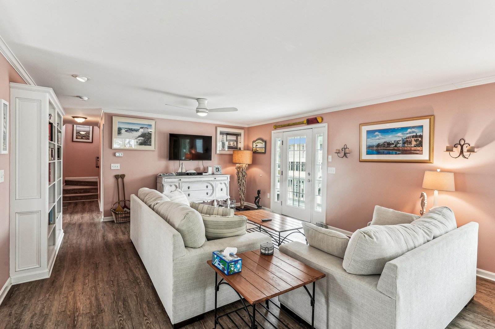 Relax in your cozy living room with plush seating and soft coral walls, perfect for unwinding after a day of exploring.