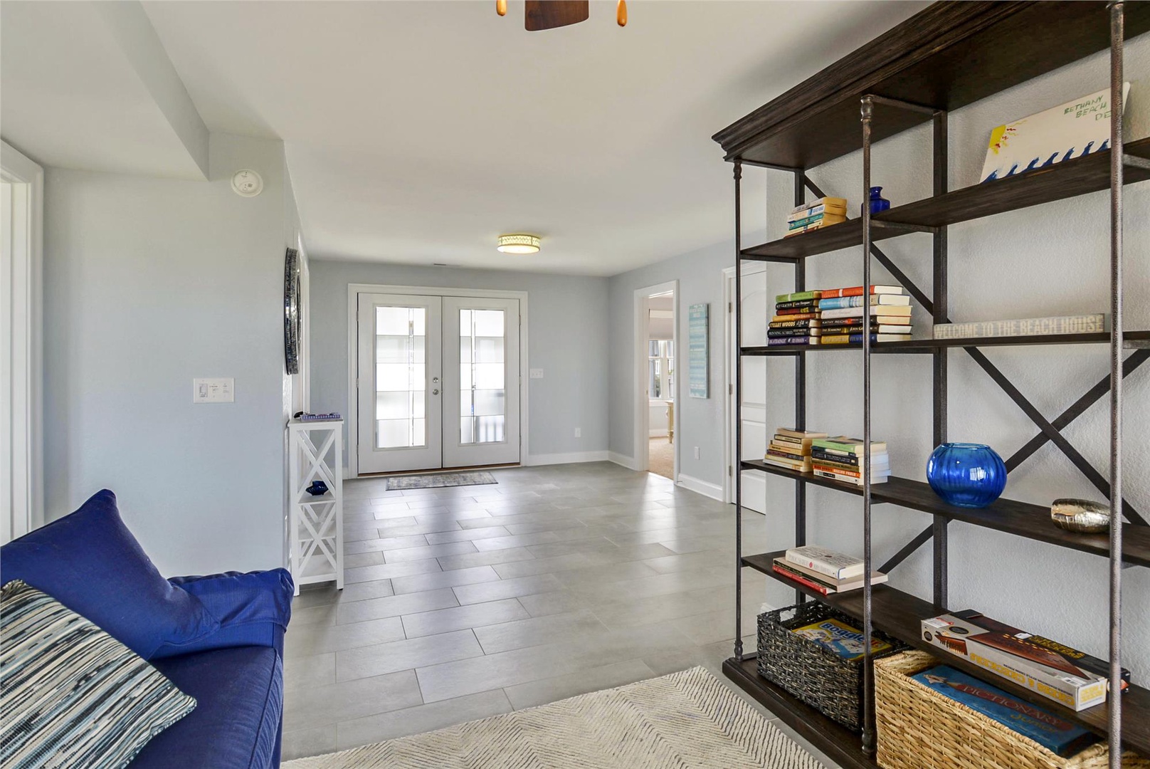 Step into your bright, welcoming entryway where coastal charm meets comfort. Curl up with a book from the curated shelves, kick off your shoes on cool tile floors, and feel right at home.