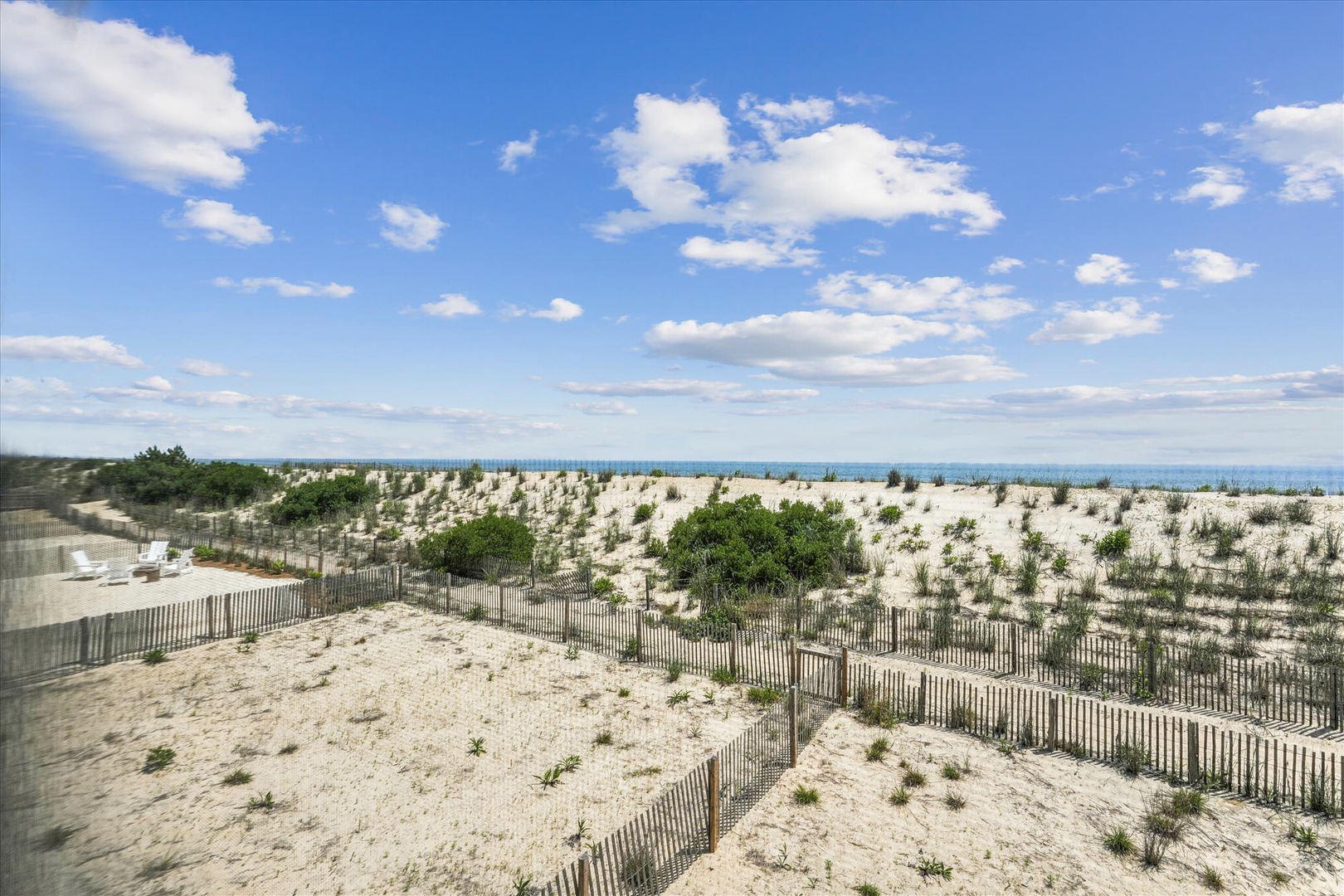 Coastal property situated near pristine sand dunes and ocean views, with natural beach vegetation and scenic shoreline access.