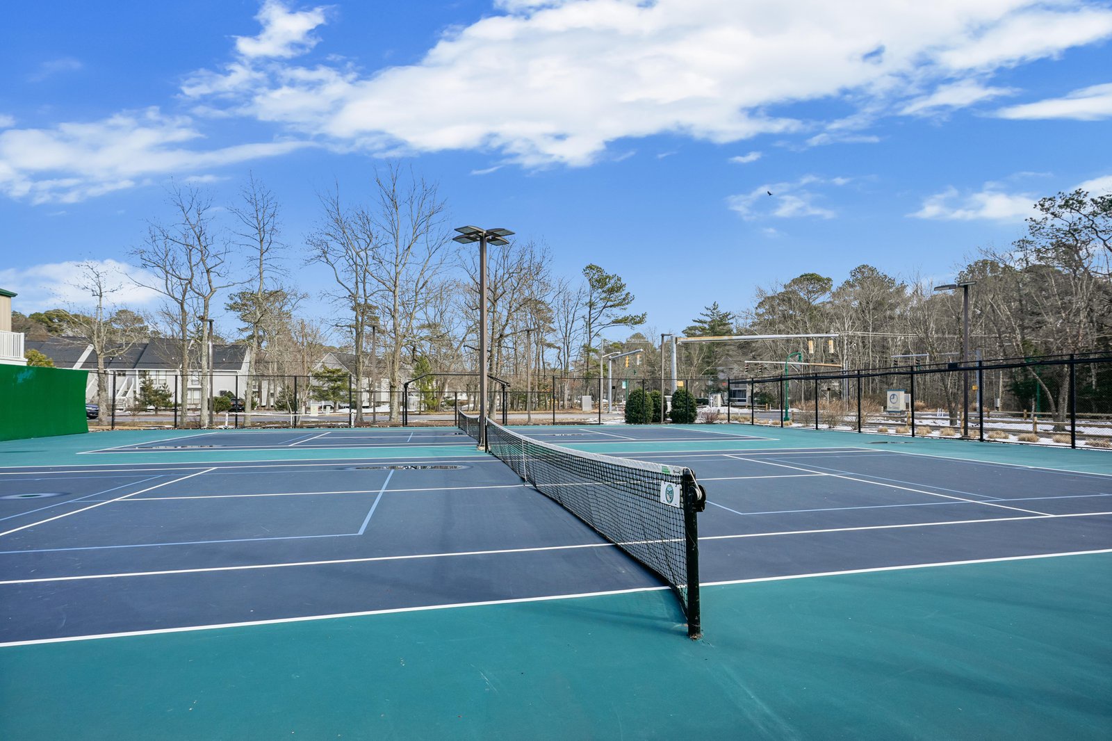 Professional tennis courts await, offering a perfect setting for a friendly match or solo practice session surrounded by open skies and natural beauty.