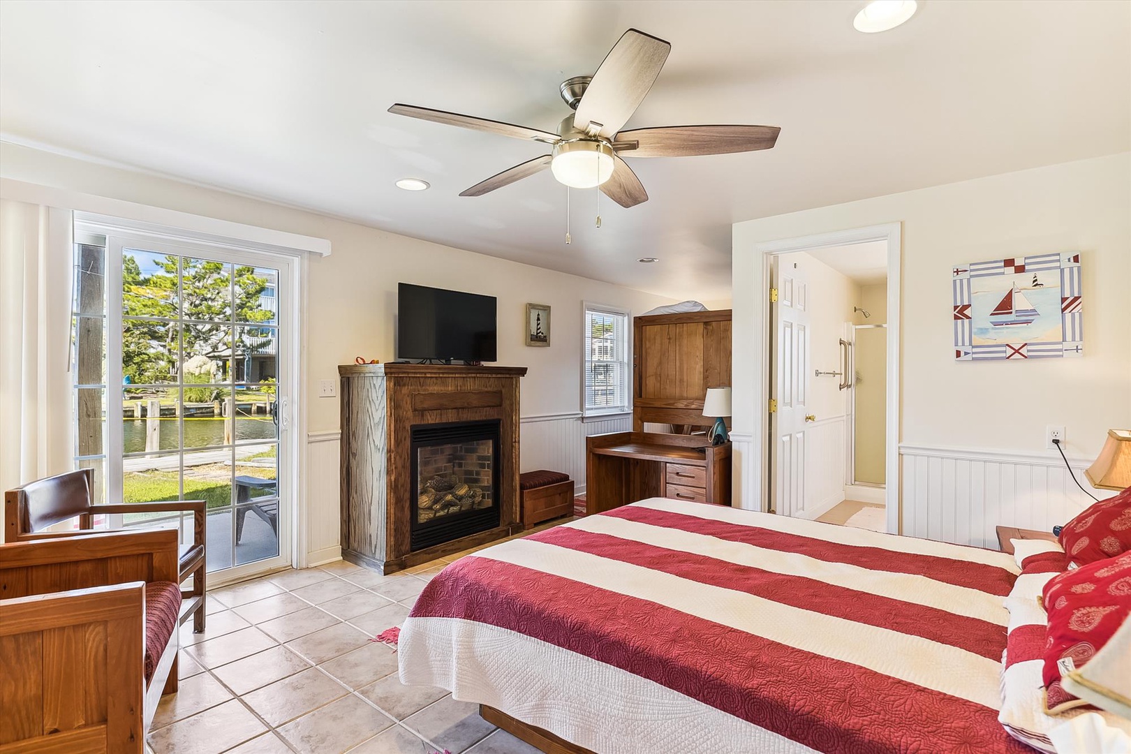 Your spacious bedroom offers comfortable furnishings, a cozy fireplace, ceiling fan, TV for entertainment, and direct access to your private outdoor space—perfect for relaxation.
