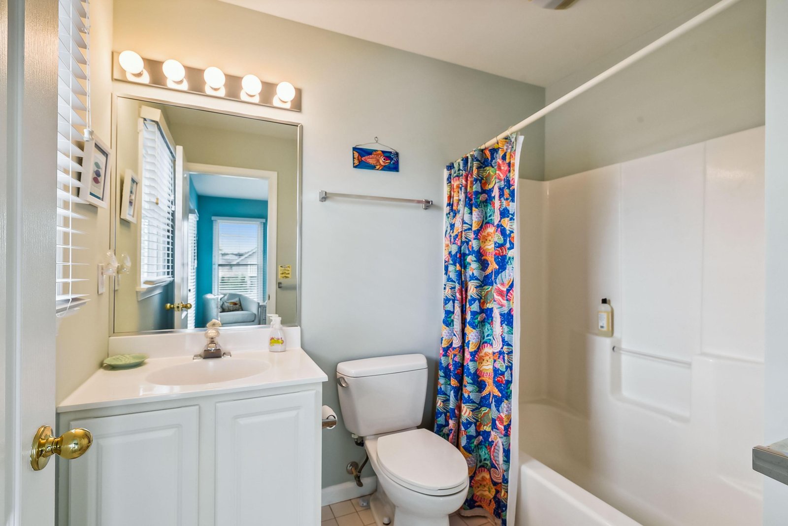 Freshen up in your bright coastal bathroom with tropical-inspired details and a cheerful shower curtain that sets a playful vacation mood.