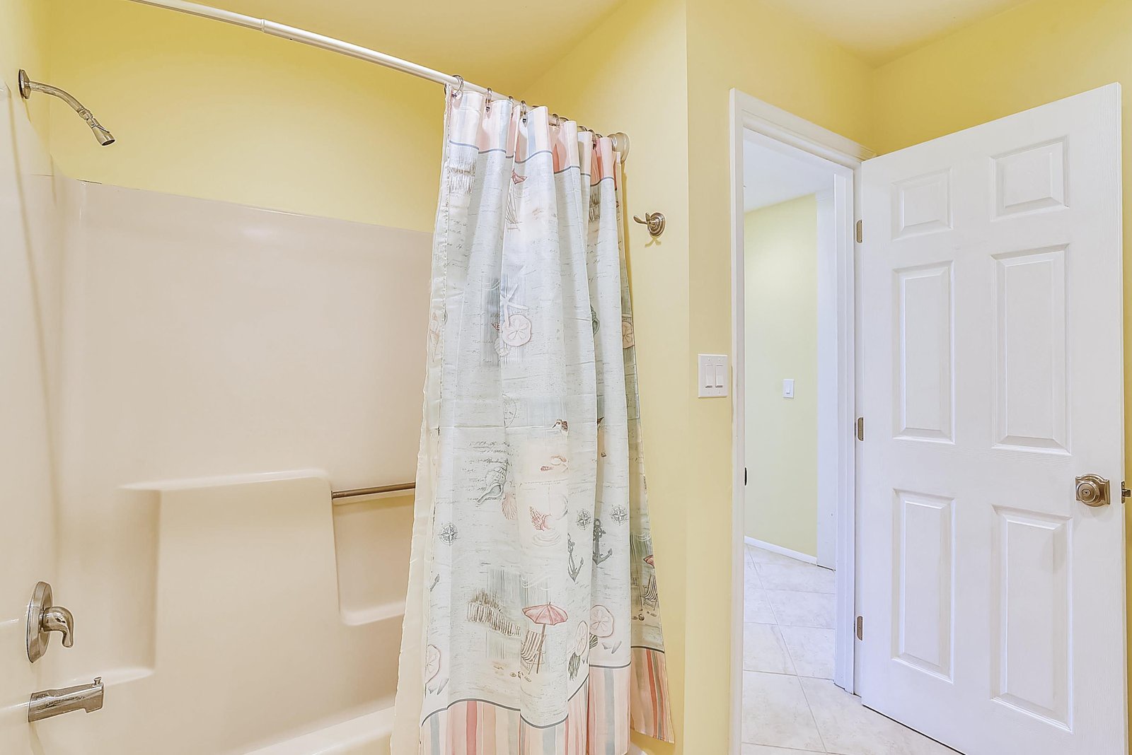 Step into your bright, cheerful bathroom with a fresh tub and shower combo, ready for a relaxing soak after a day of adventure.