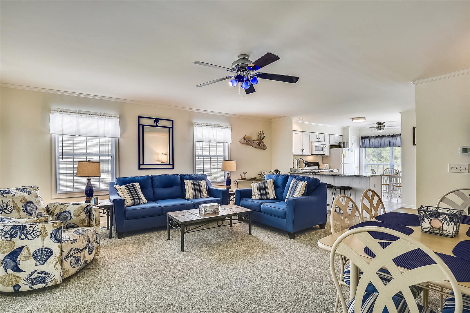 Unwind in your spacious living area with vibrant coastal-themed seating and an open layout that flows seamlessly into the kitchen, perfect for gathering with loved ones.
