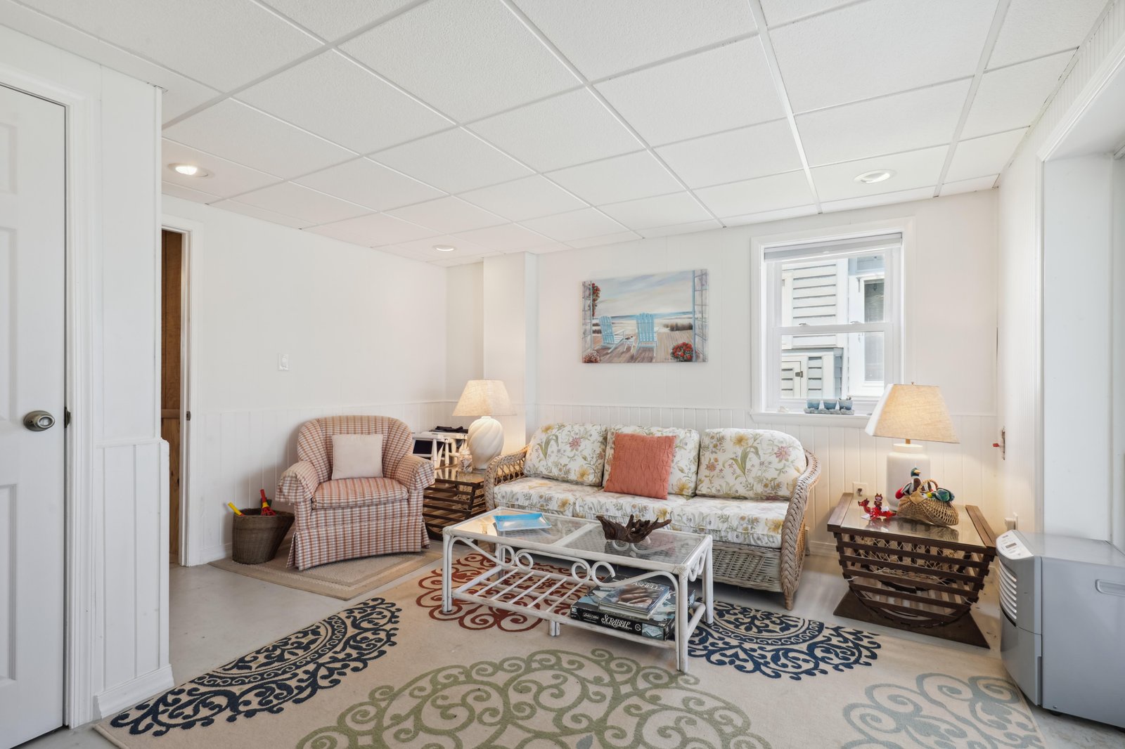 Relax in your cozy sitting room, where soft lighting and coastal accents create a welcoming retreat after a long day exploring the area.
