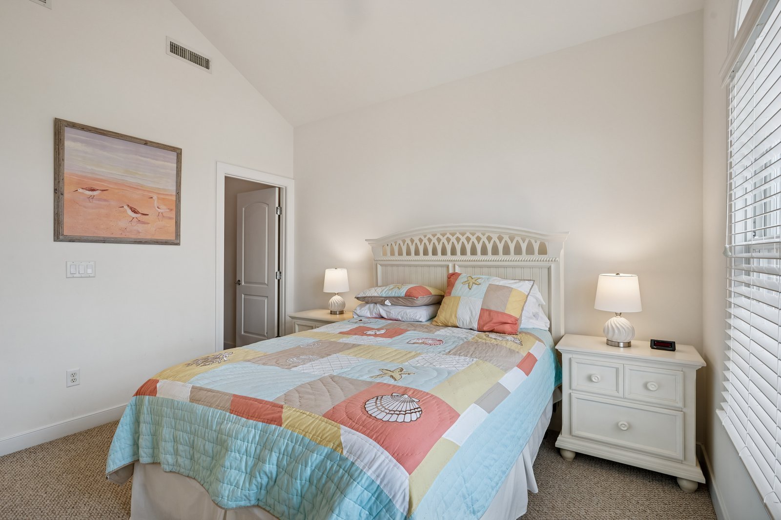 Rest peacefully in your bright bedroom with coastal-themed bedding and soft lighting creating a serene seaside sanctuary.