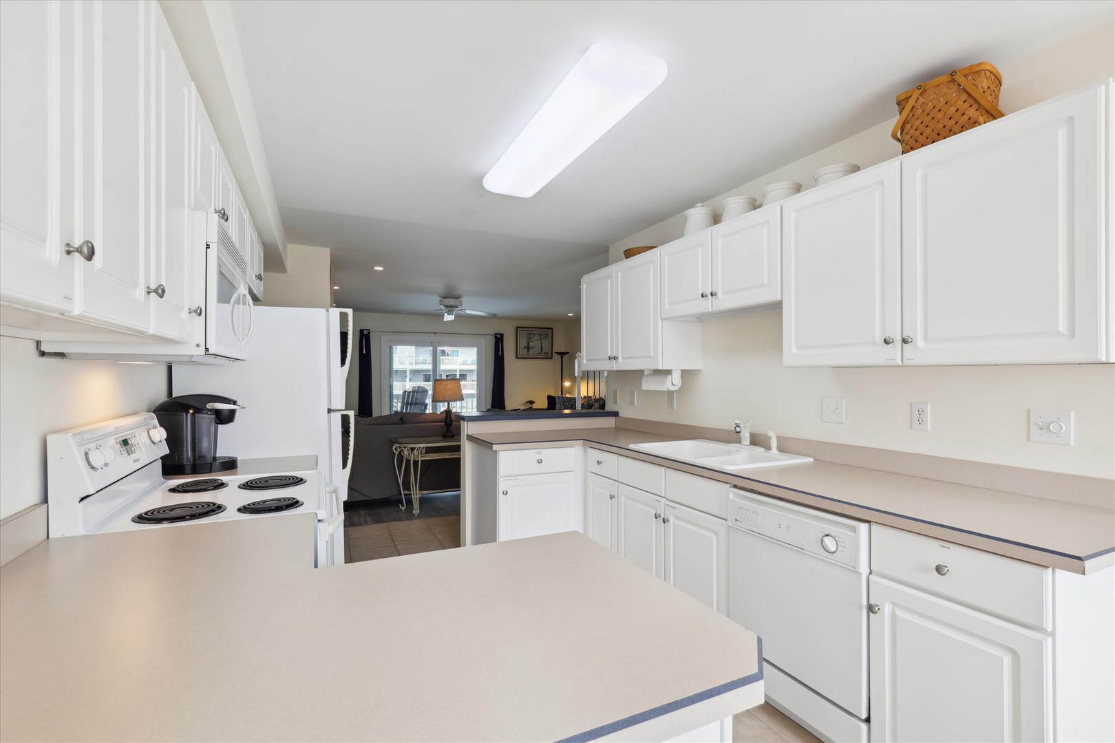 A bright, spacious kitchen awaits your culinary adventures, with gleaming white cabinets, ample counter space, and modern appliances—everything you need to prepare meals comfortably during your stay.
