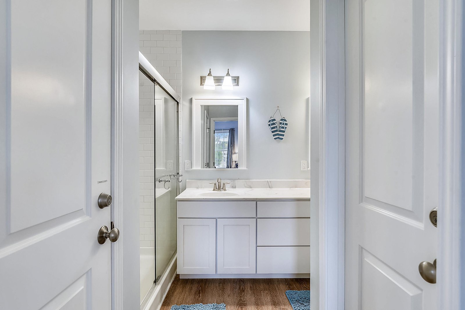 Step into your bright, spotless bathroom with crisp white cabinetry, gleaming countertops, and a tranquil coastal charm that makes every morning feel refreshing.