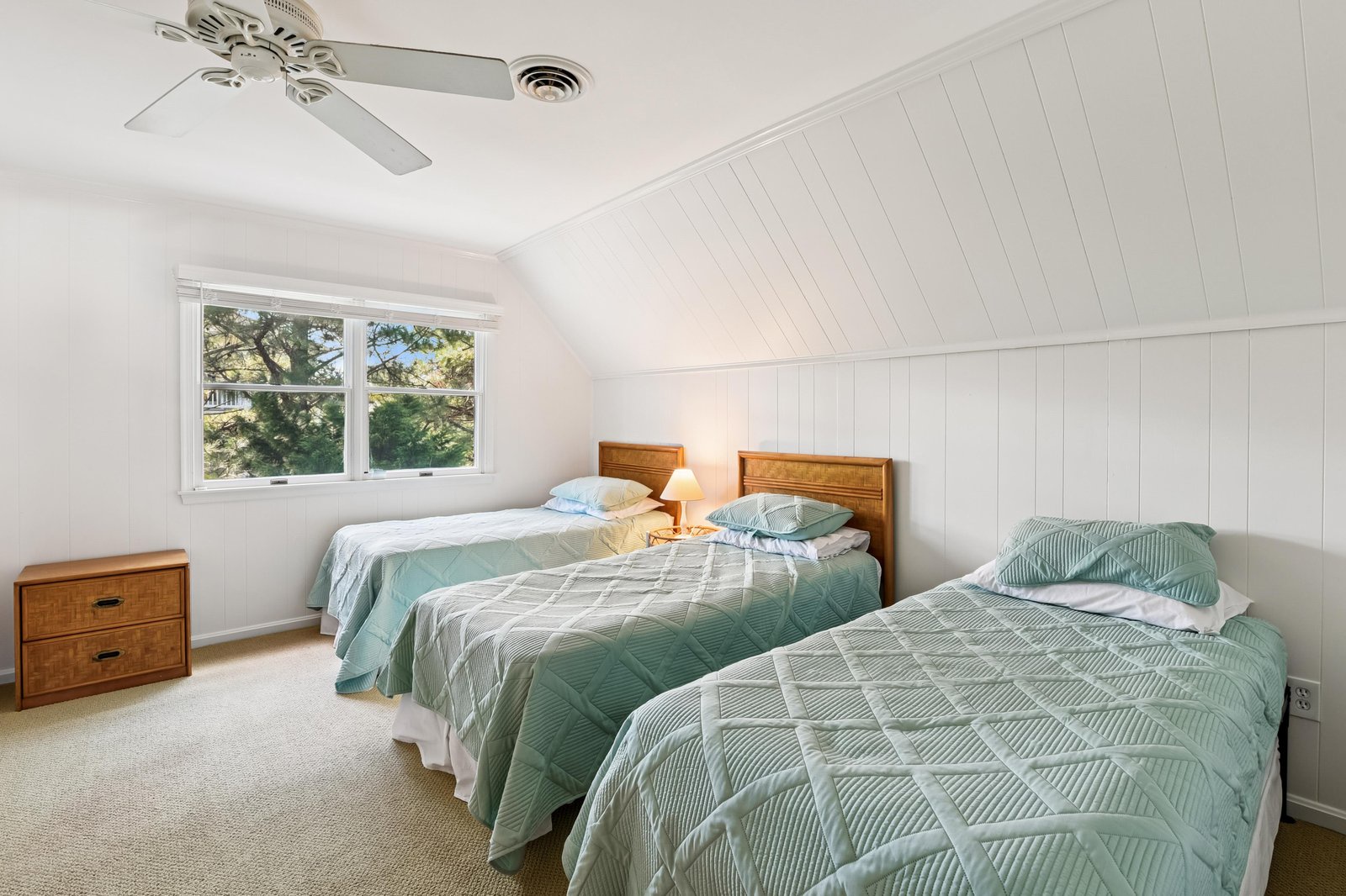 A peaceful bedroom with three cozy beds, soft linens, and natural light—your restful retreat after a day of adventure awaits here.