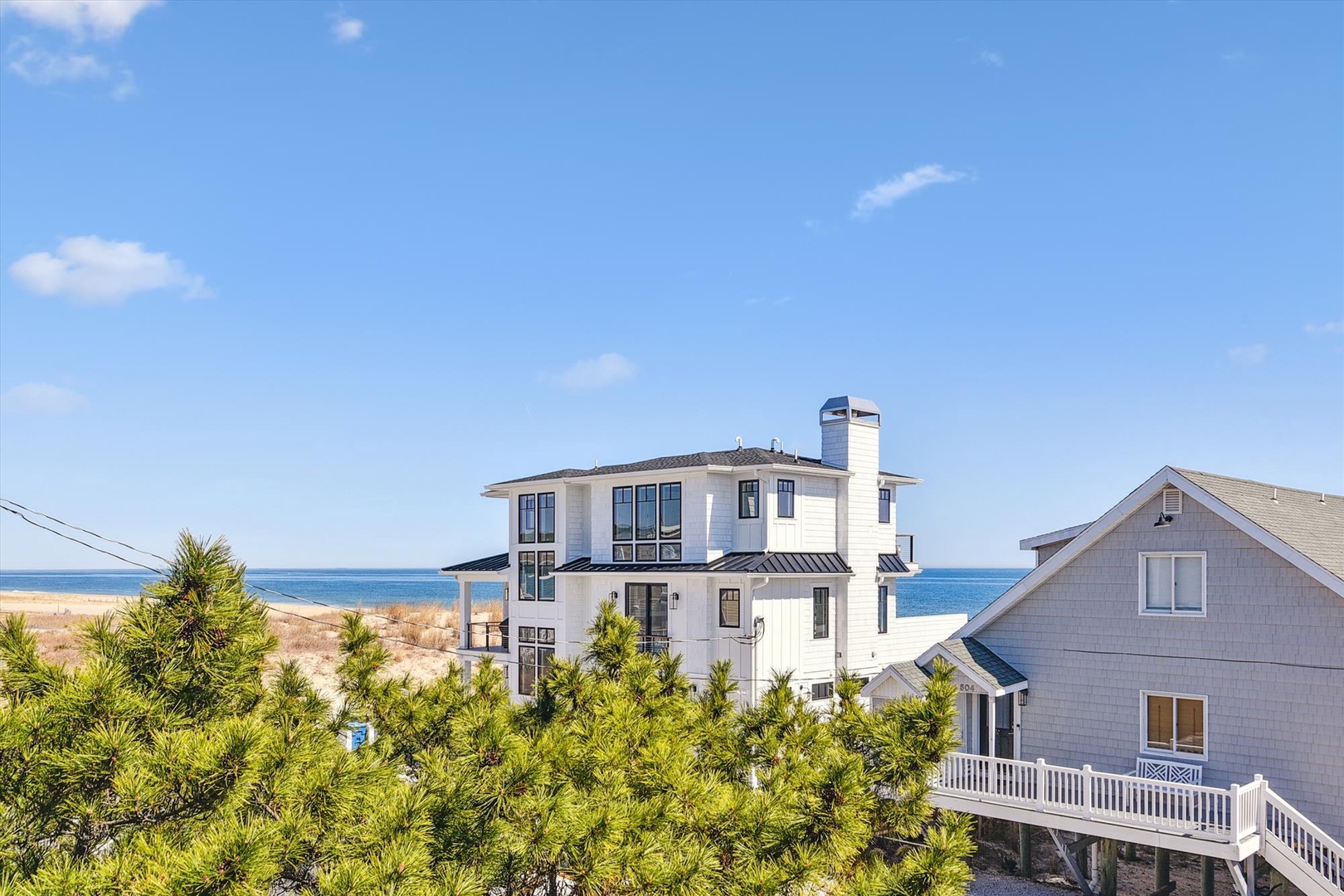 Stunning beachfront property with panoramic ocean views, nestled among coastal homes just steps from pristine sandy shores.