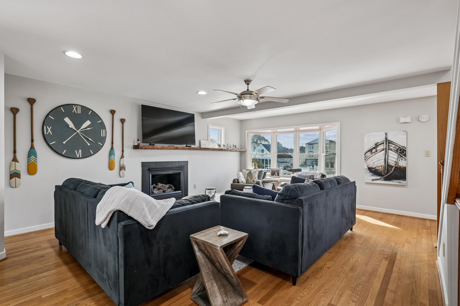 Sink into plush couches and unwind by the fireplace, where coastal charm meets comfort. Your peaceful retreat awaits, complete with cozy throws and serene neighborhood views.