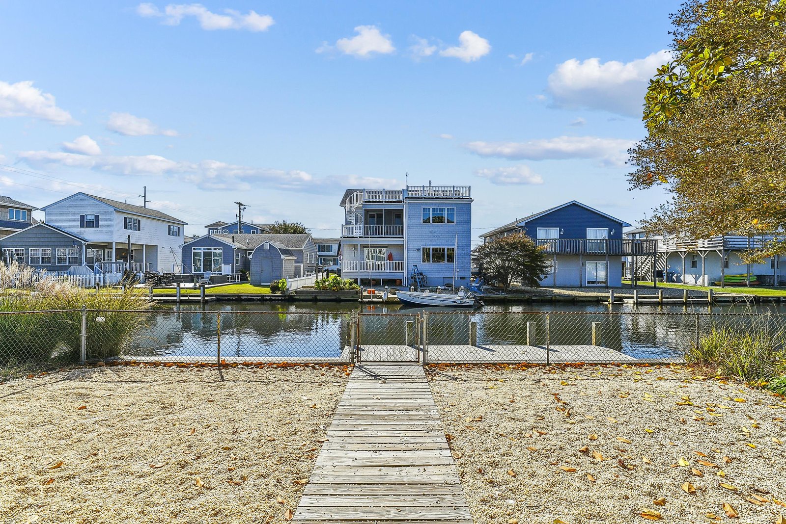 A scenic waterfront canal community with private dock access and coastal homes nestled along peaceful waterways, framed by open skies and seasonal foliage.