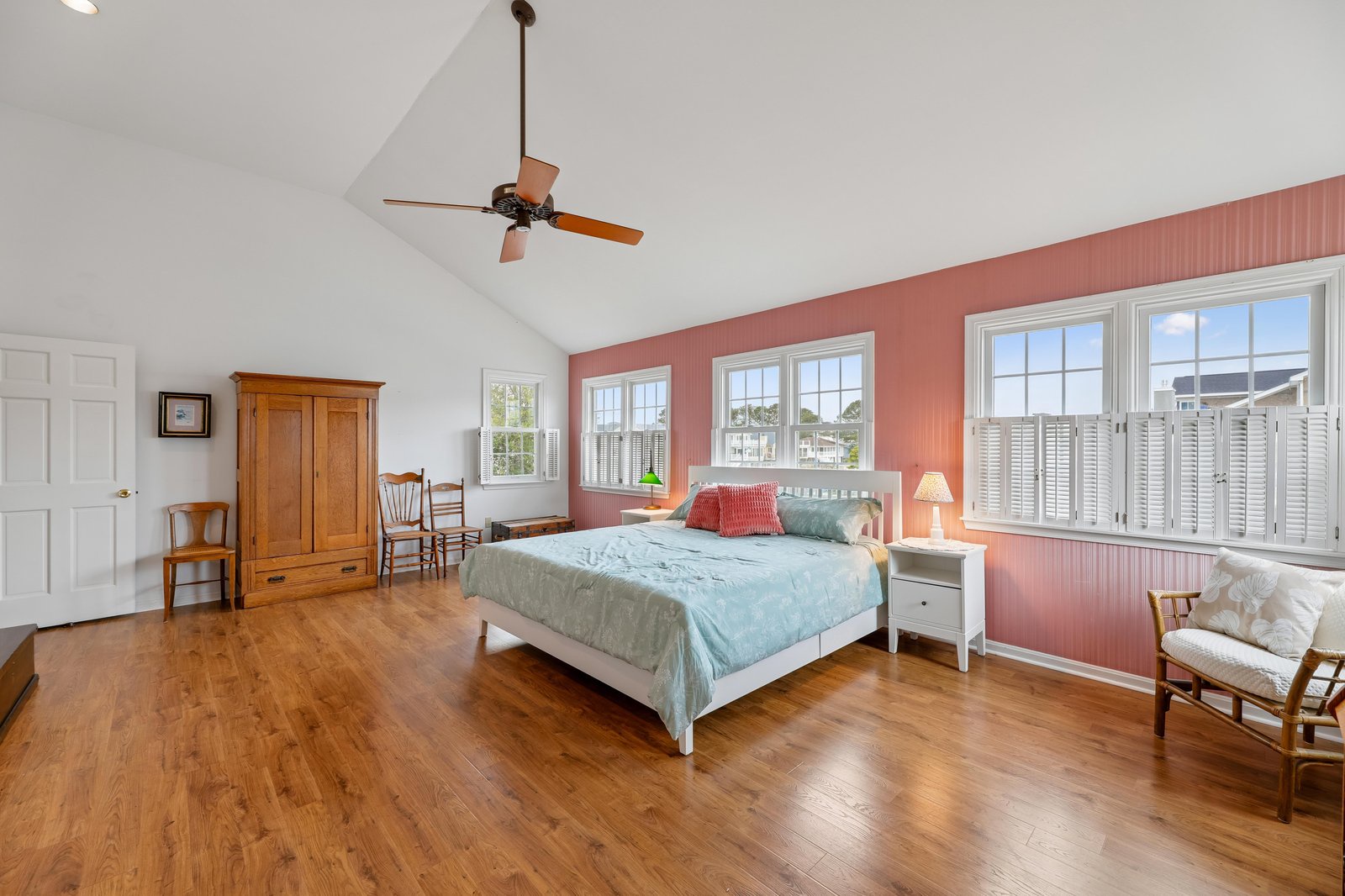 Settle into your spacious bedroom where vaulted ceilings and warm hardwood floors create an airy, welcoming retreat. Natural light pours through large windows, while the ceiling fan keeps the space comfortable year-round.