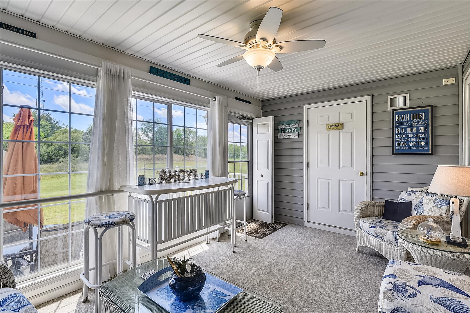 This bright screened porch invites you to unwind with morning coffee or evening drinks. Natural breezes flow through while you take in peaceful views of the surrounding landscape, perfect for relaxing after a beach day.