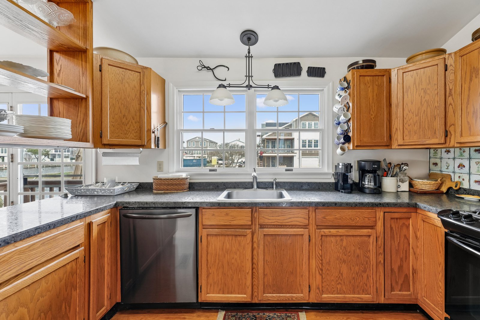 Prepare your favorite meals in this inviting kitchen with granite counters, warm wood cabinetry, and lovely waterfront views right from your sink.