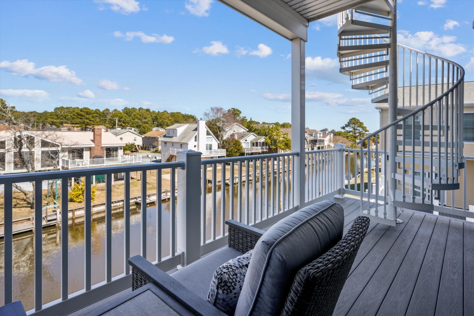 Your private balcony features a cozy seating area where you can sip morning coffee while watching boats drift by on the calm canal below, surrounded by coastal charm.