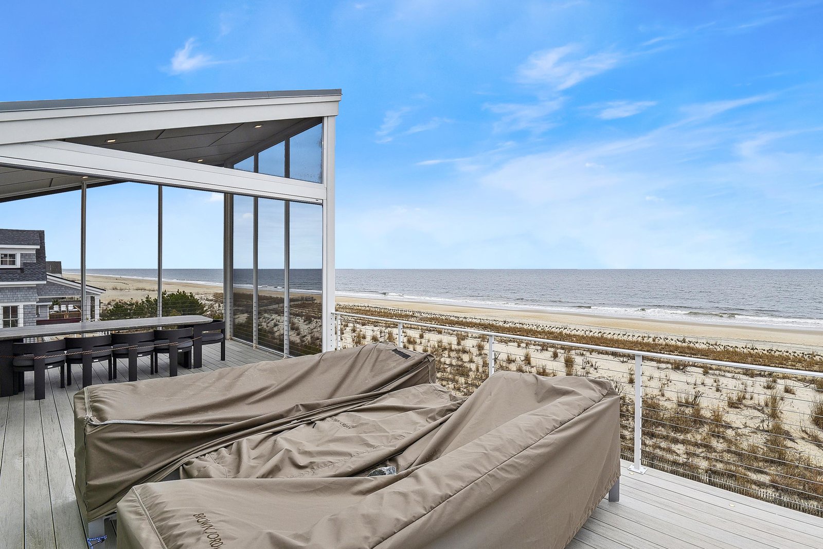 Unwind on the sun-drenched deck where plush lounge chairs frame an uninterrupted stretch of sandy beach and sparkling ocean—your private retreat for soaking in the coastal beauty.