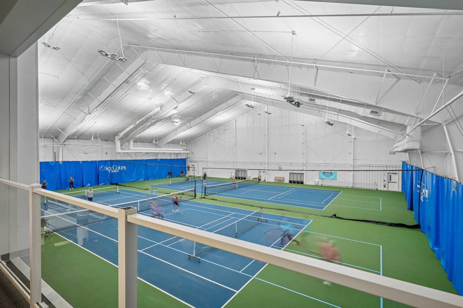 Indoor tennis courts with professional surfaces and nets, offering year-round play under bright, climate-controlled conditions.