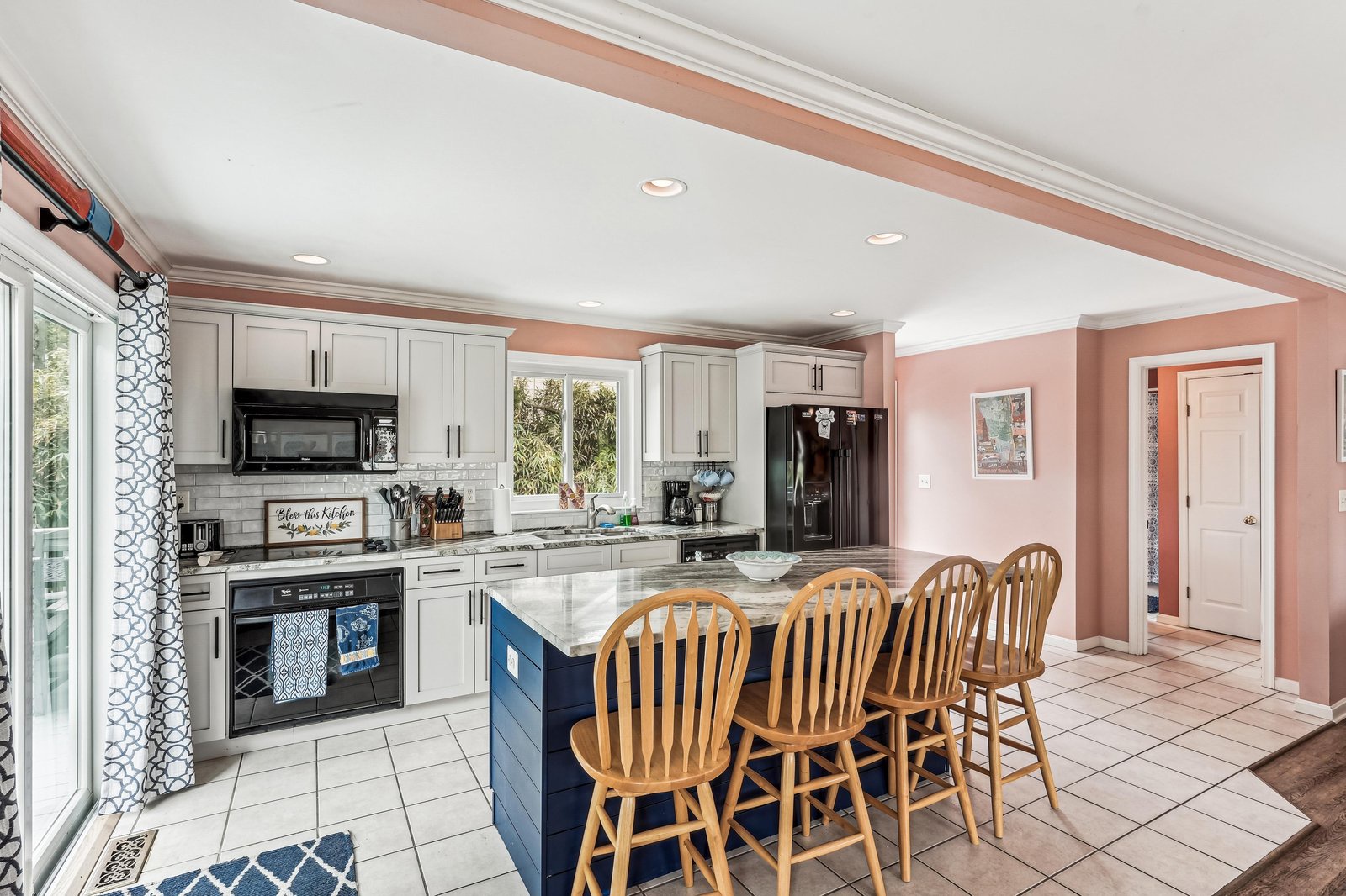 Gather around the spacious island and feel right at home in this bright, fully-equipped kitchen—your perfect spot for morning coffee or preparing meals together.