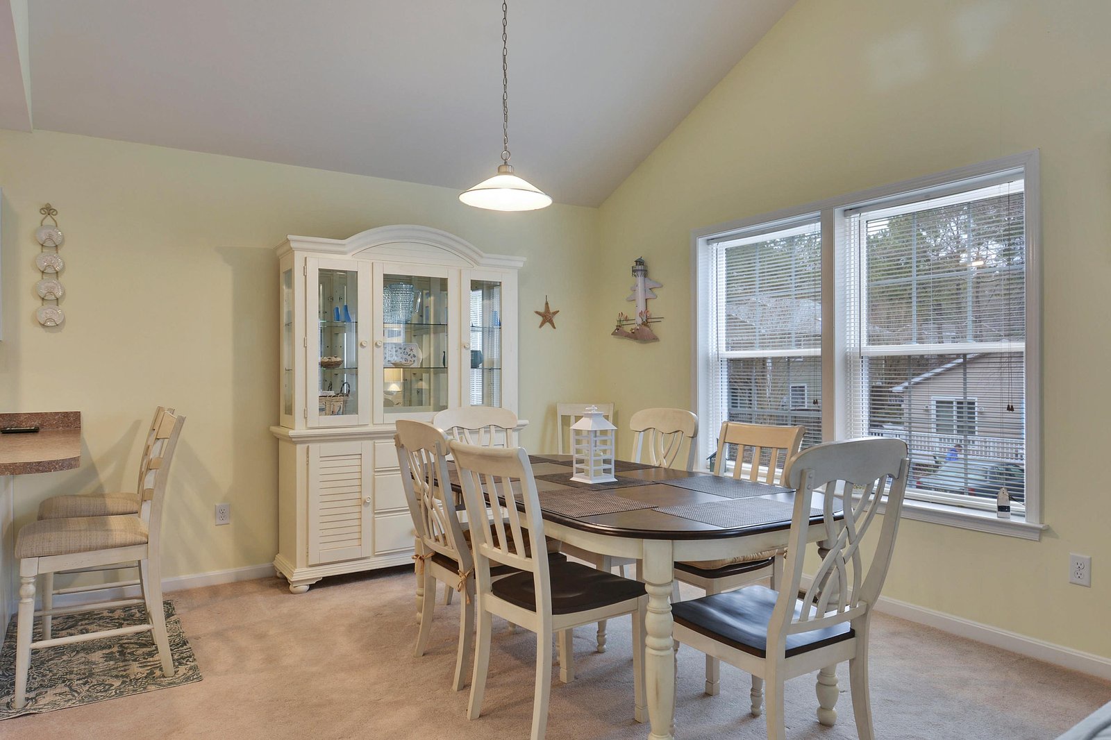 Gather around the inviting dining table where you'll share meals and make memories together. Bright windows fill the space with natural light, while the charming hutch adds character to your home away from home.