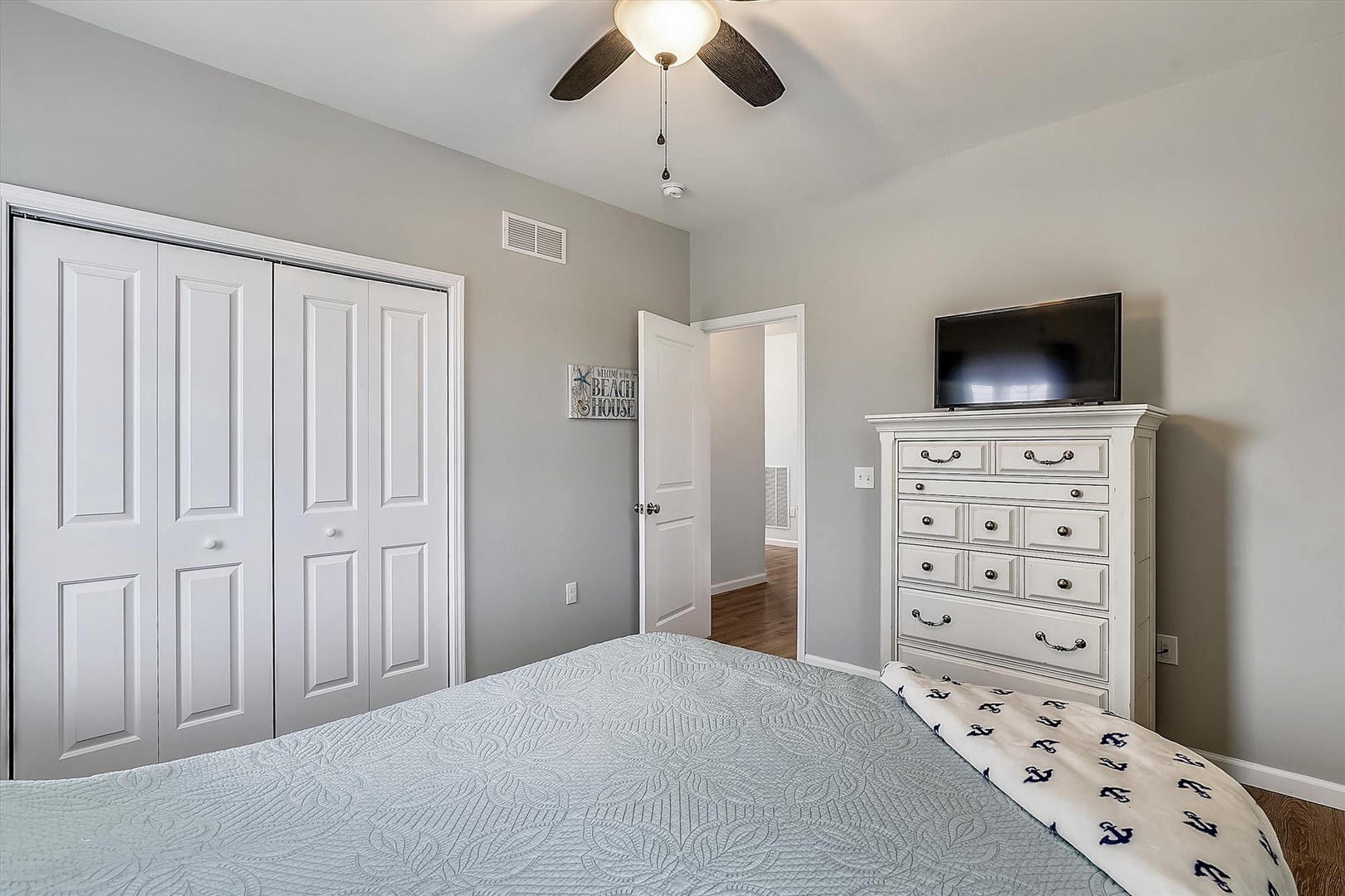 Drift off in this calming bedroom with soft linens, ceiling fan overhead, and plenty of storage space for your belongings throughout your stay.