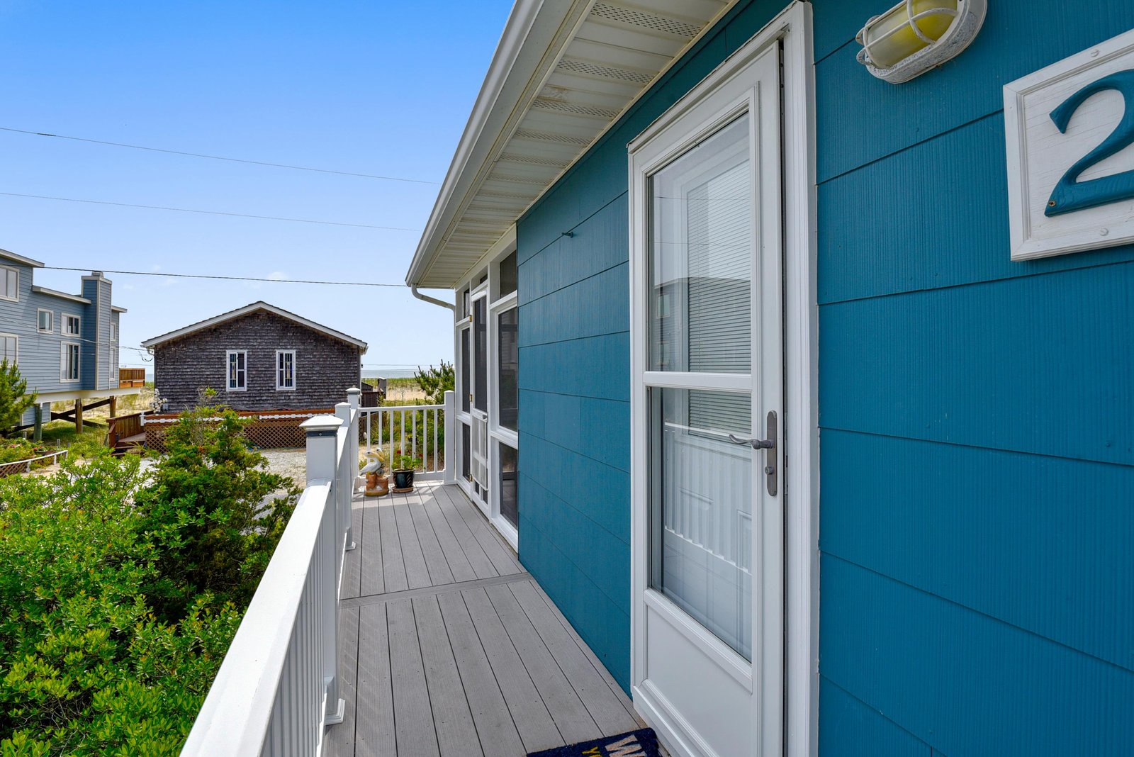 Bright coastal balcony with charming neighborhood and natural landscape views framing your coastal retreat.