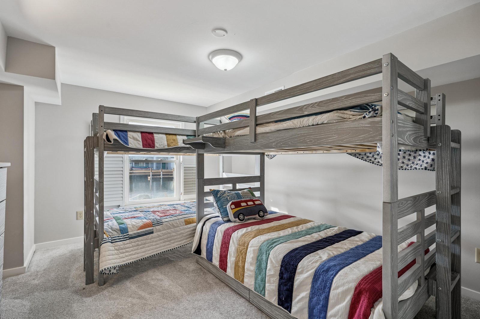 Settle in for the night in this cozy bunk room, where sturdy wooden bunks and colorful quilts create a playful, welcoming space perfect for restful sleep.