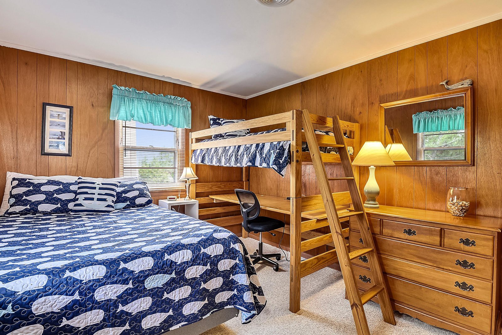 You'll love the warm wood paneling and cheerful nautical linens in this cozy bedroom. The bunk bed and double bed offer flexible sleeping arrangements, perfect for families looking to spread out comfortably.