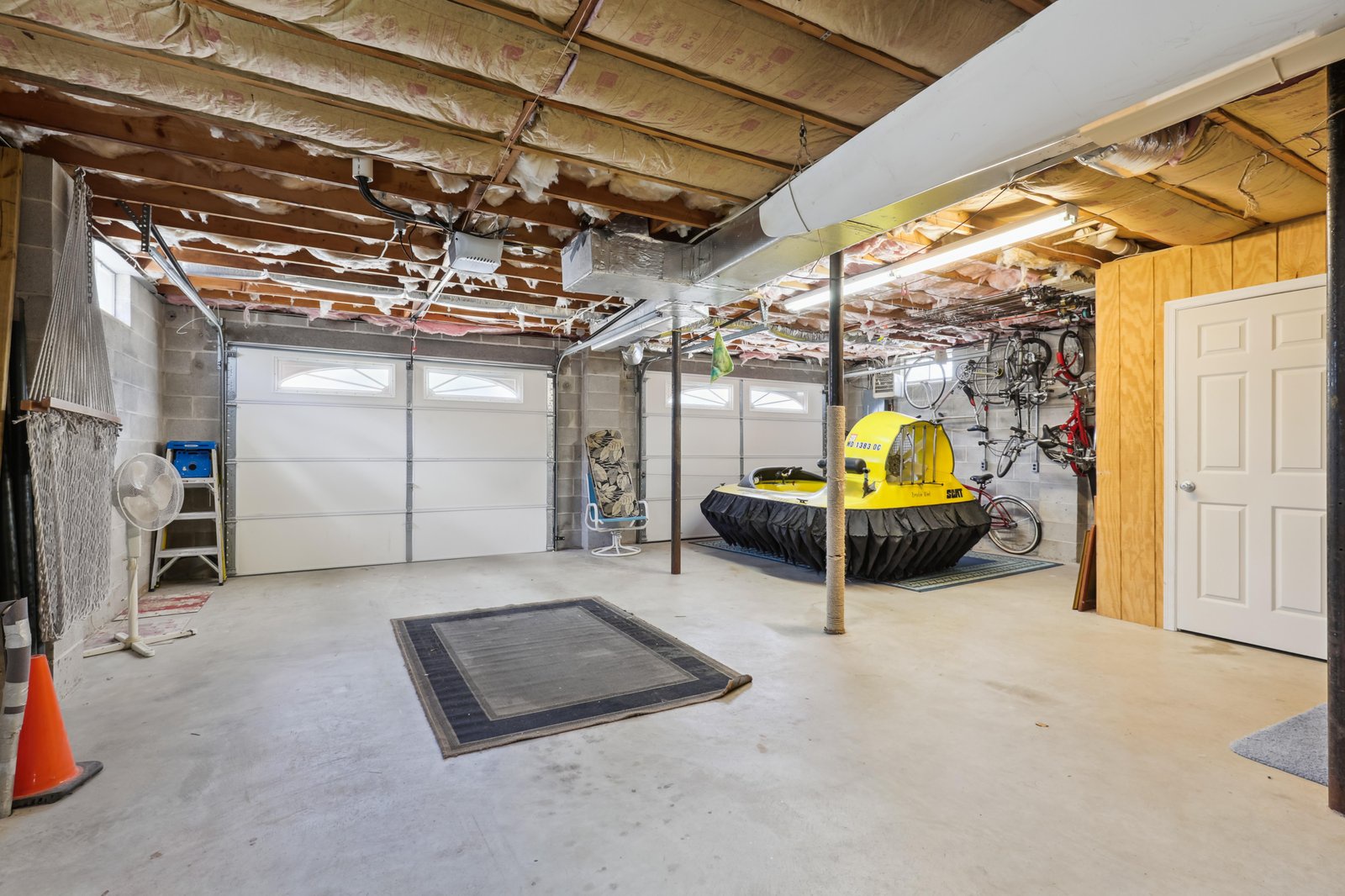 A spacious garage with exposed beam ceilings and a creative workout zone featuring oversized tractor tires—perfect for storing bikes, gear, and anything else you need during your stay.