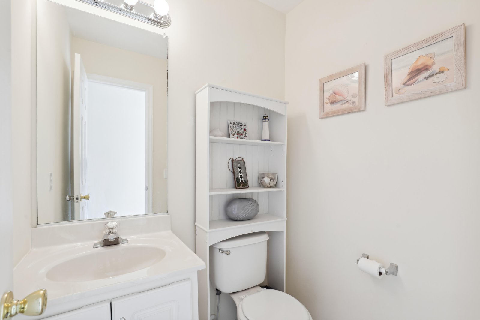 Your private bathroom offers a fresh, clean space with thoughtful touches. Seashell artwork sets a calming coastal tone, while the over-toilet shelving keeps essentials neatly organized—everything you need for a comfortable stay.